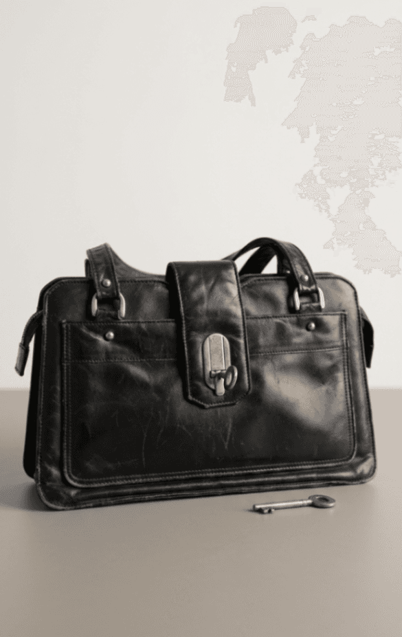 Bolso de cuero marrón y negro y pantuflas.