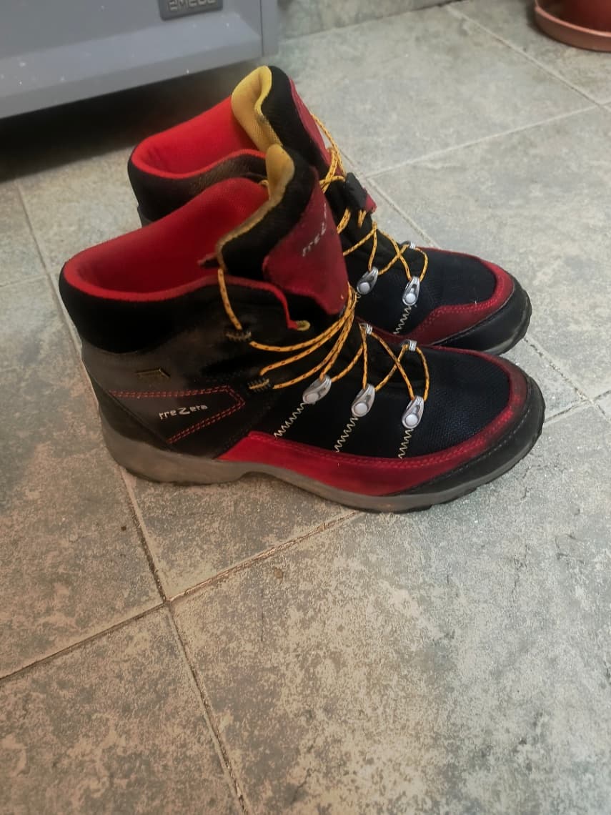 Botas de trekking rojas y negras usadas