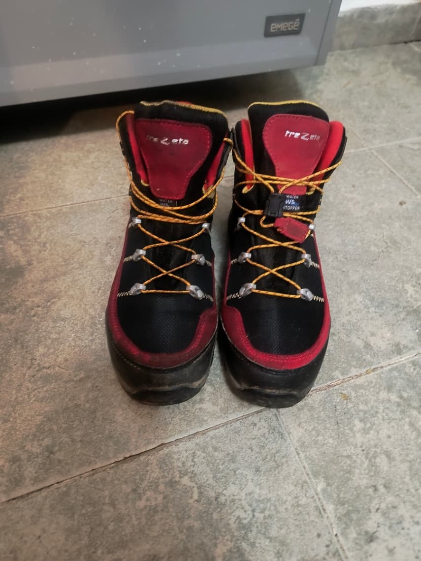 Botas de trekking rojas y negras usadas